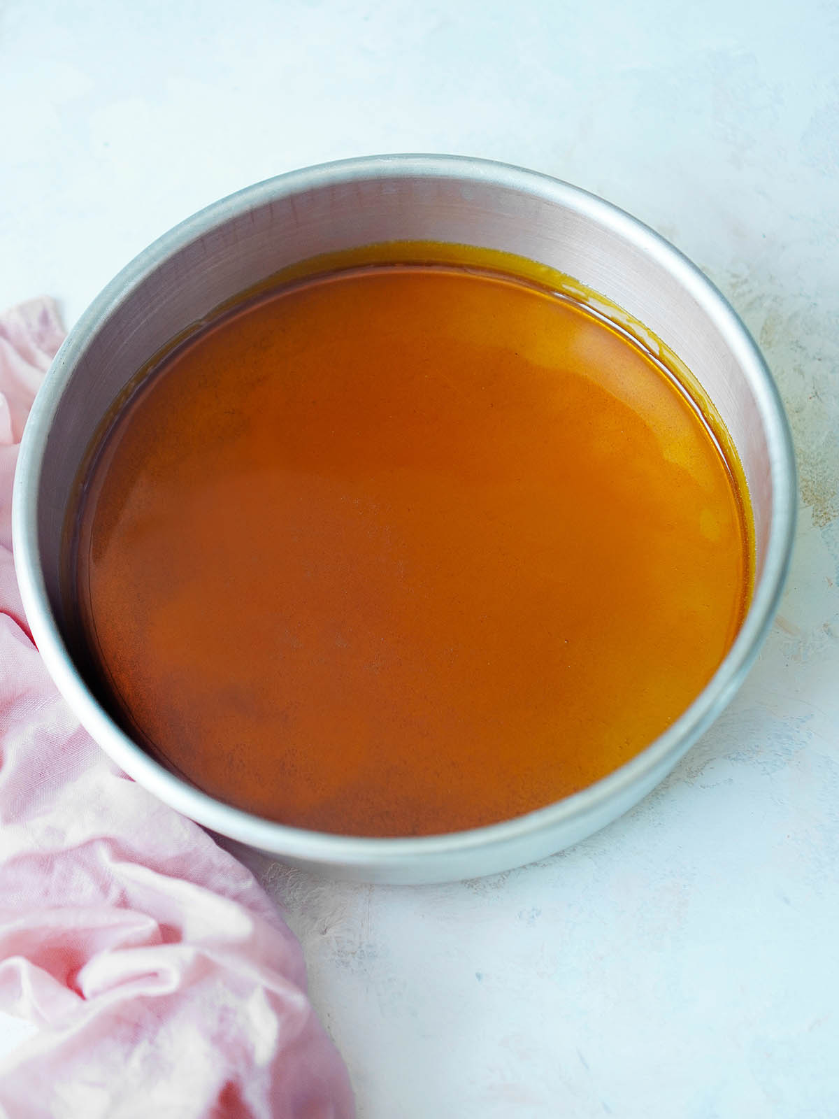 A baking round pan with caramel sauce. 