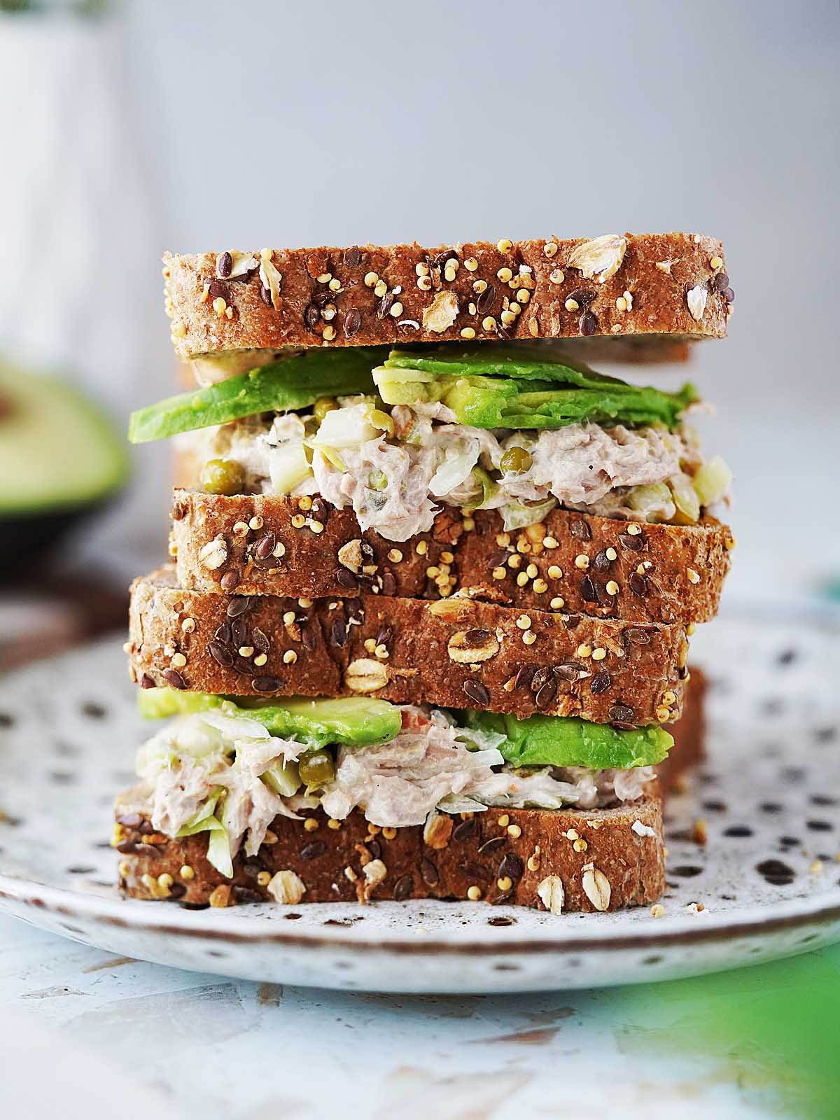 Two tuna salad sandwiches stacked on top of each other.