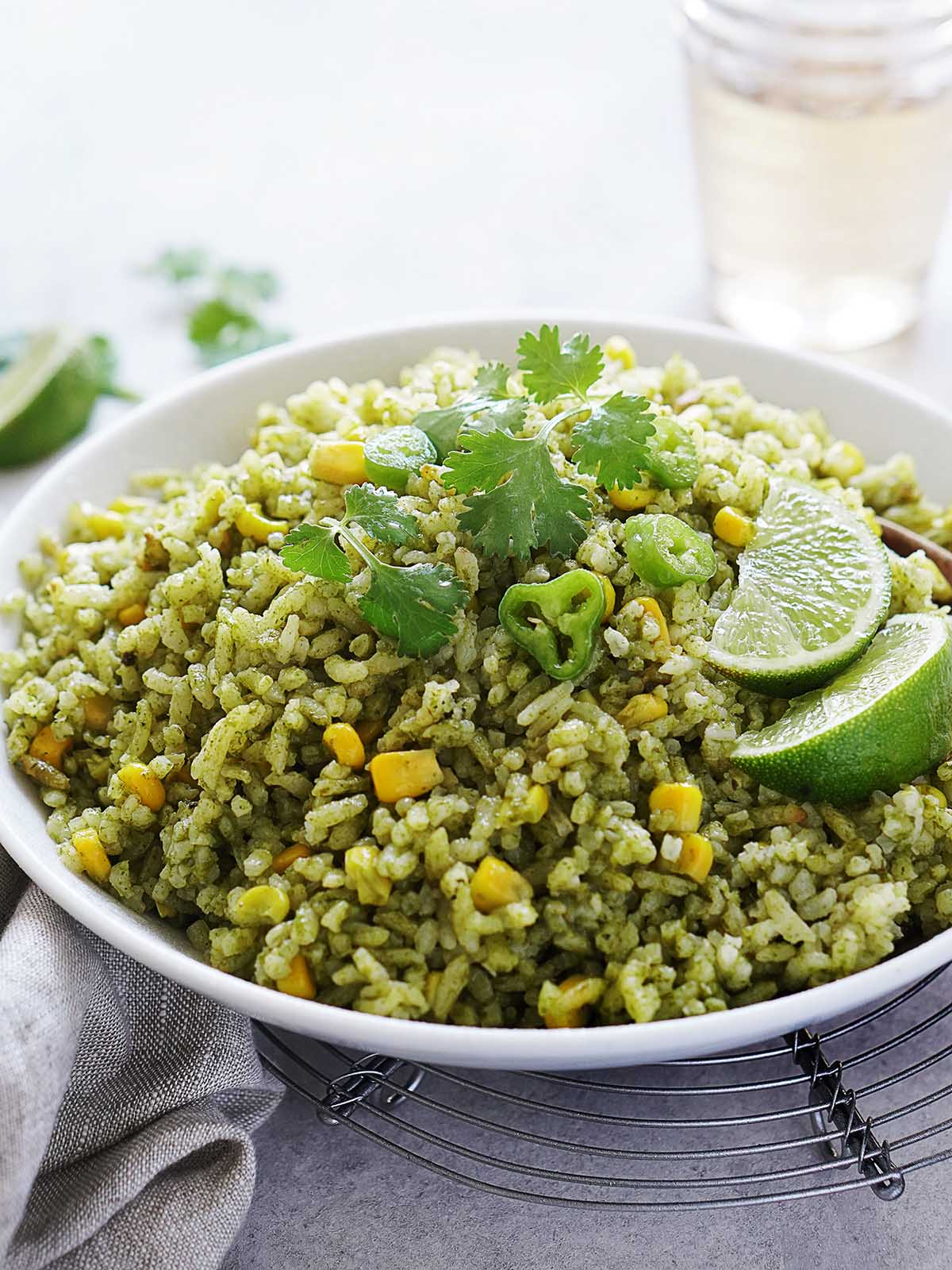 A white bowl with arroz verde garnished with cilantro and sliced peppers.