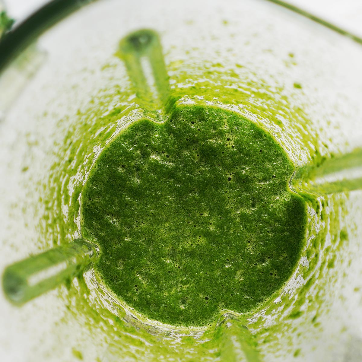 A blender's glass with the green sauce made of poblano peppers, cilantro and spinach.
