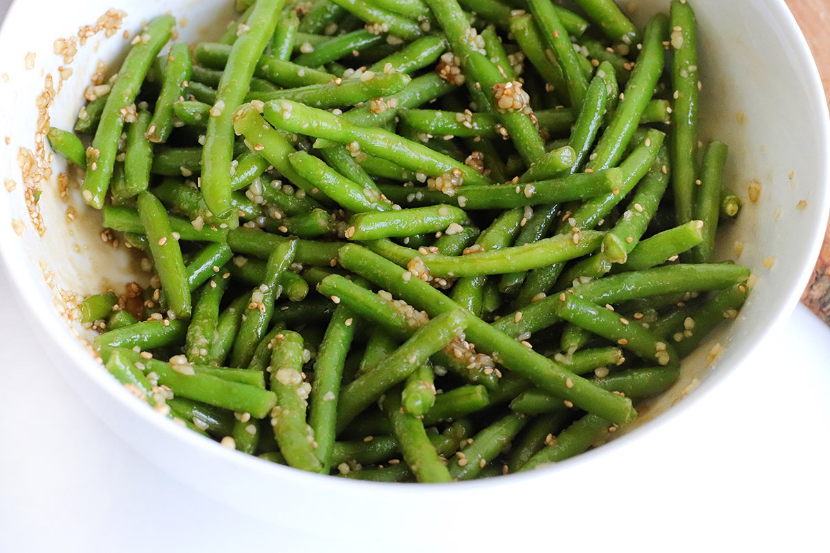 A white bowl with frozen green beans.