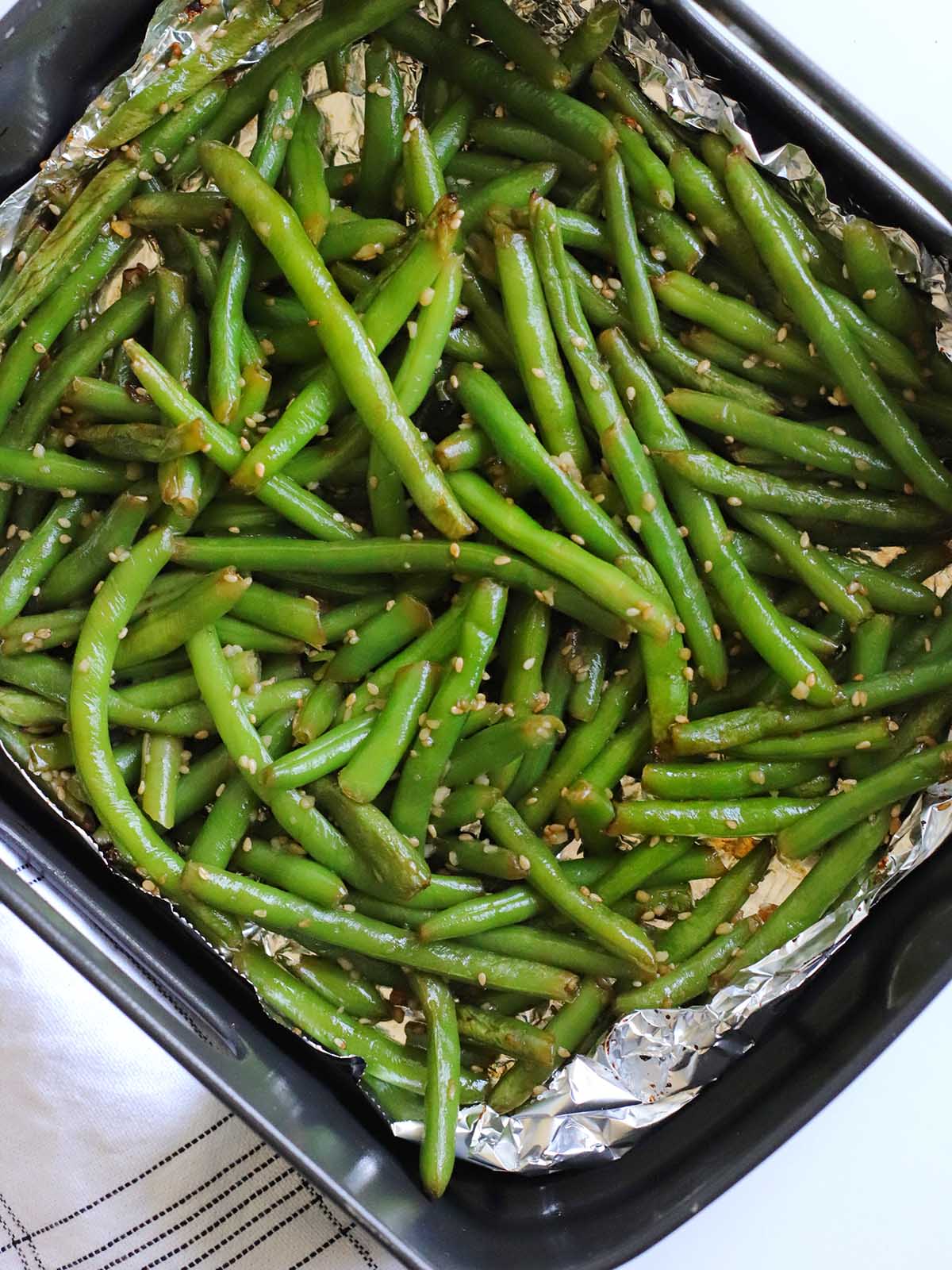 Cooked Green Beans on a baking tray lined with foil.
