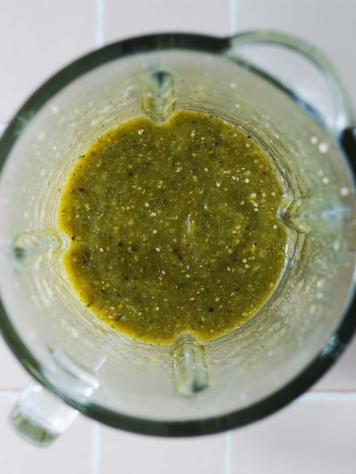 Blended green salsa in the blender's glass.
