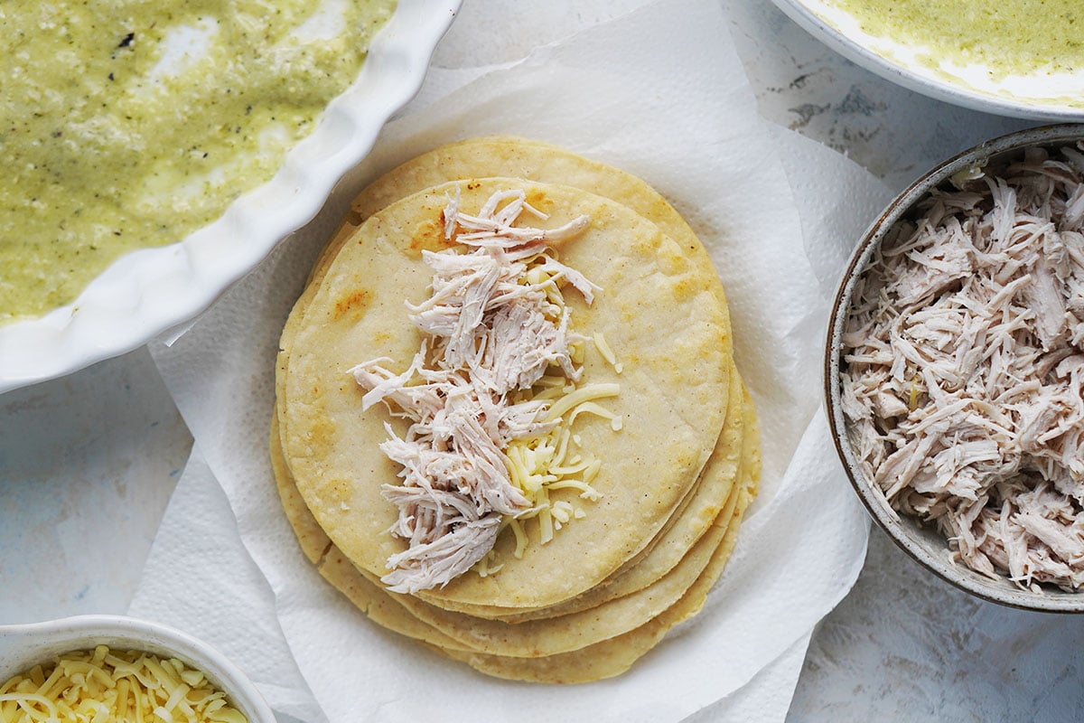 A stack of fried corn tortillas topped with shredded chicken and cheese.