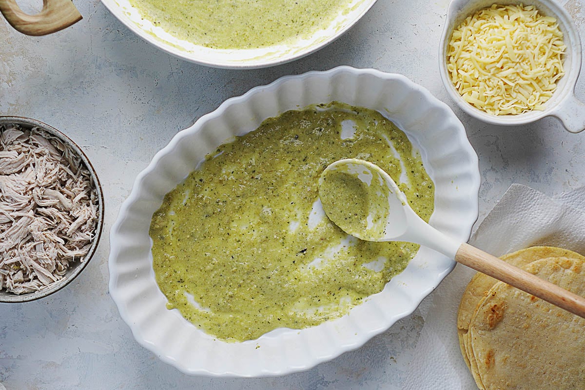 A white oval baking dish with a green sauce..