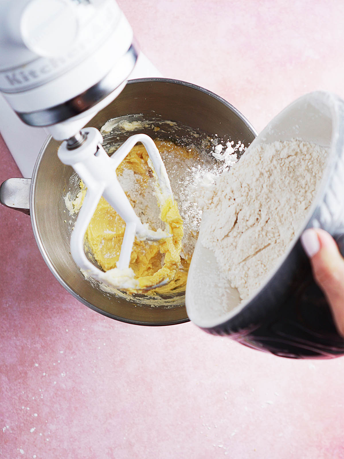 Pouring flour into a stand mixer.