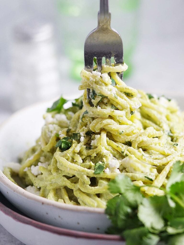 A bowl with espagueti verde garnished with fresh cilantro.