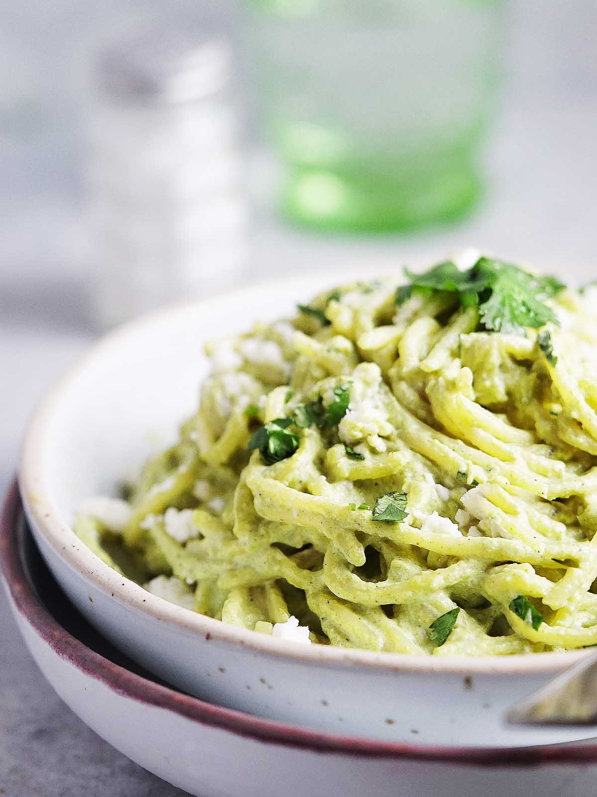 A bowl with espagueti verde garnished with fresh cilantro.