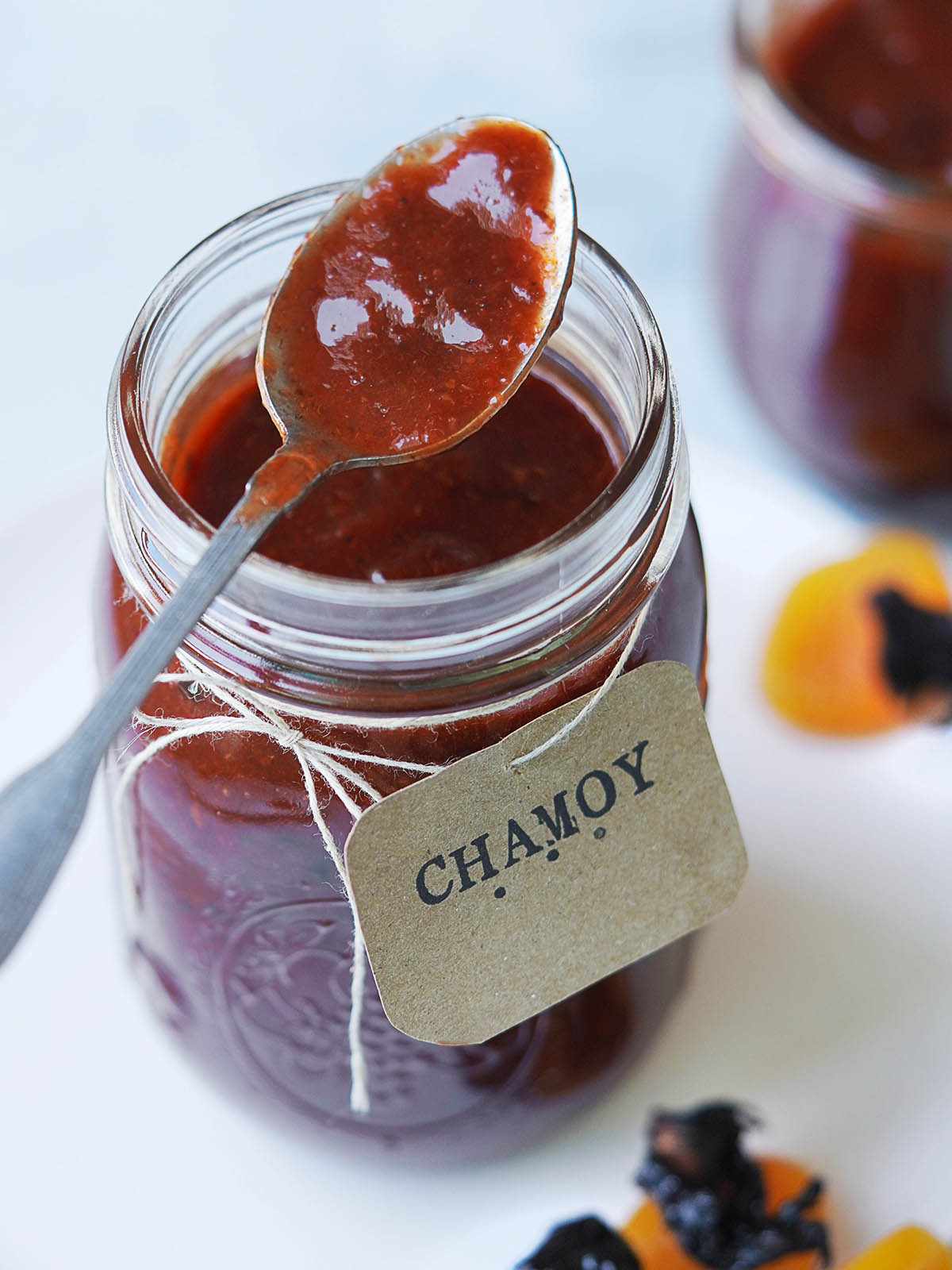 Chamoy on a spoon with a jar and a Chamoy sign.