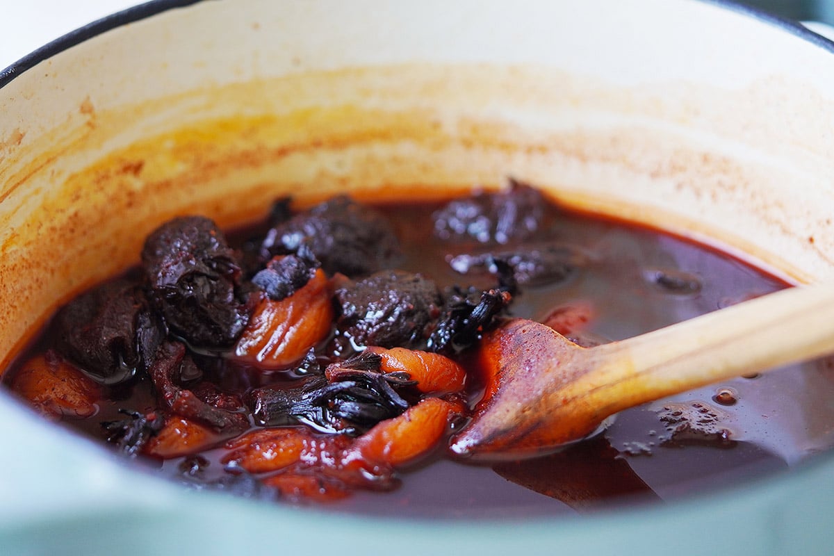 Cooked jamaica flowers, apricots and prunes in a saucepan.