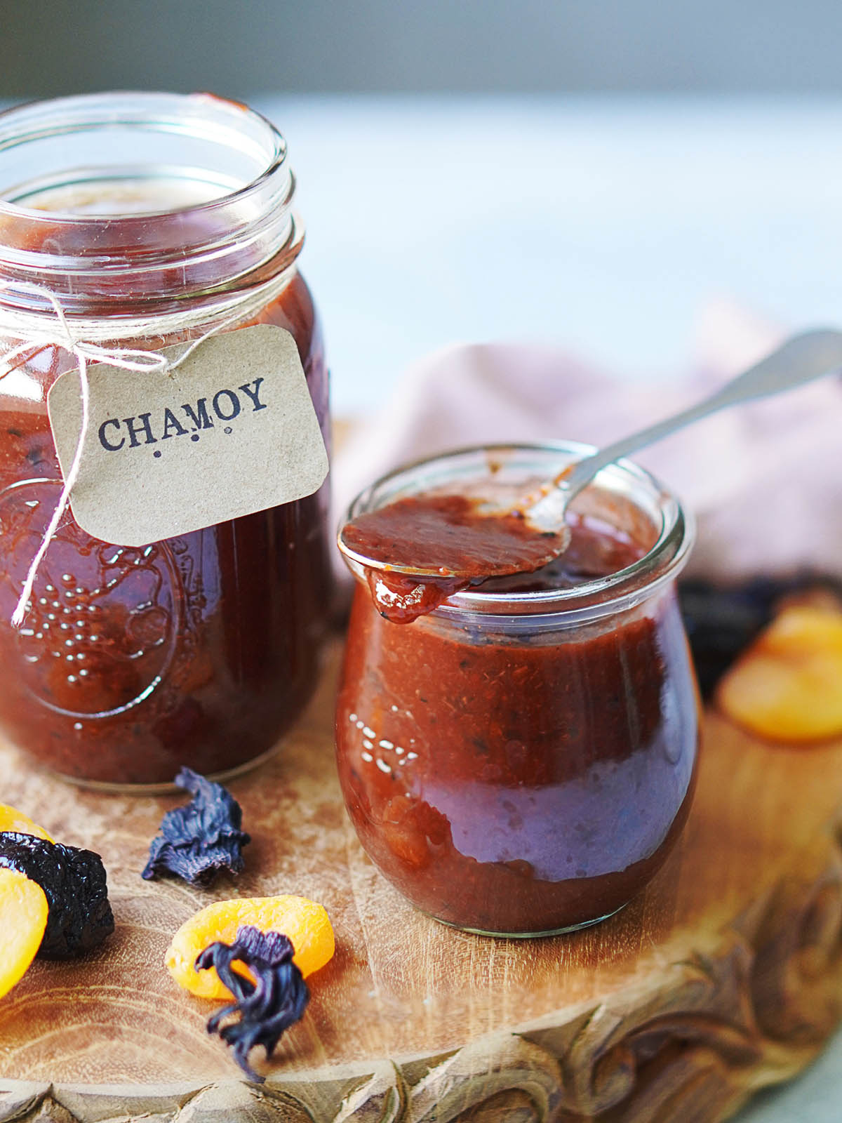 Two small jars with Chamoy placed on a wood board.