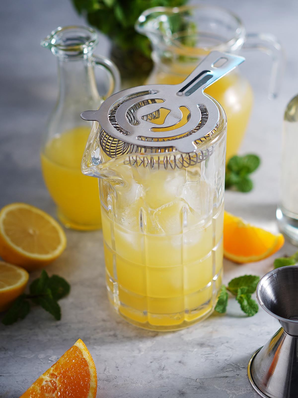 A cocktail shaker with a cocktail mix of orange and lemon juice.