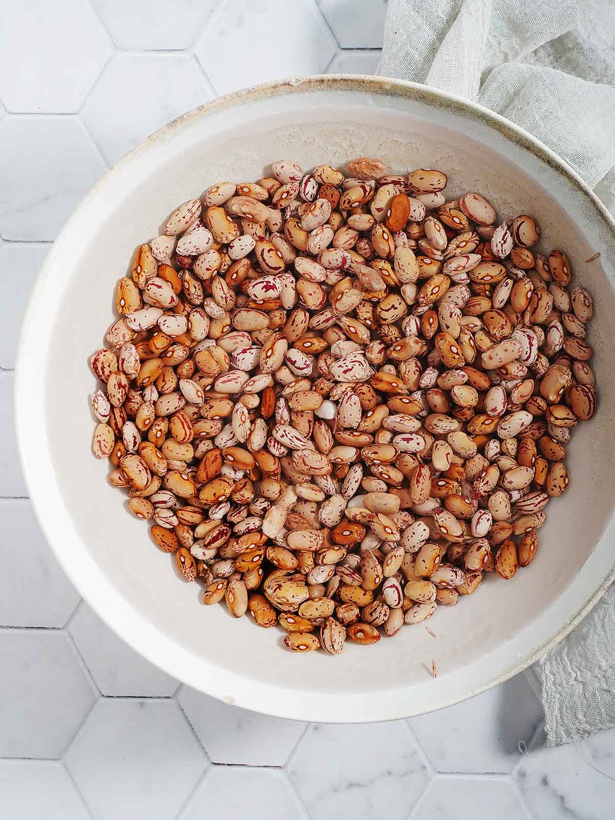 Soaking beans with water in a large bowl.