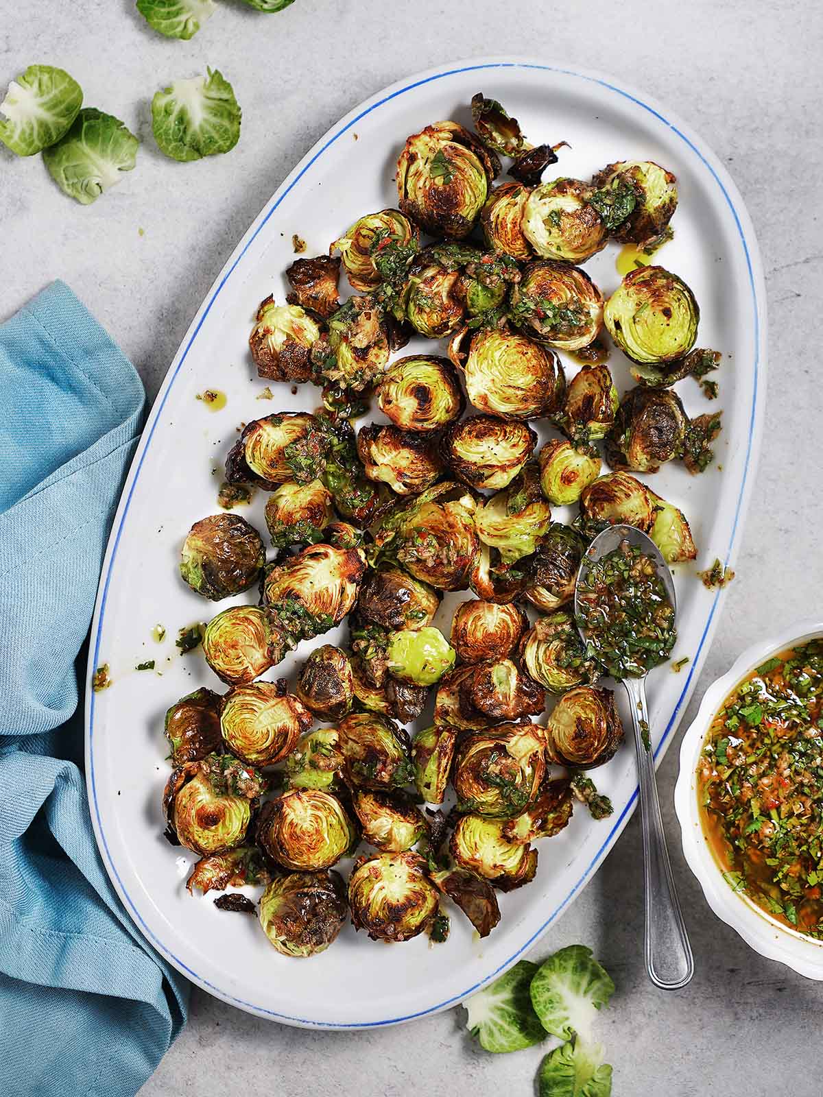 An oval plate with roasted brussel sprouts.