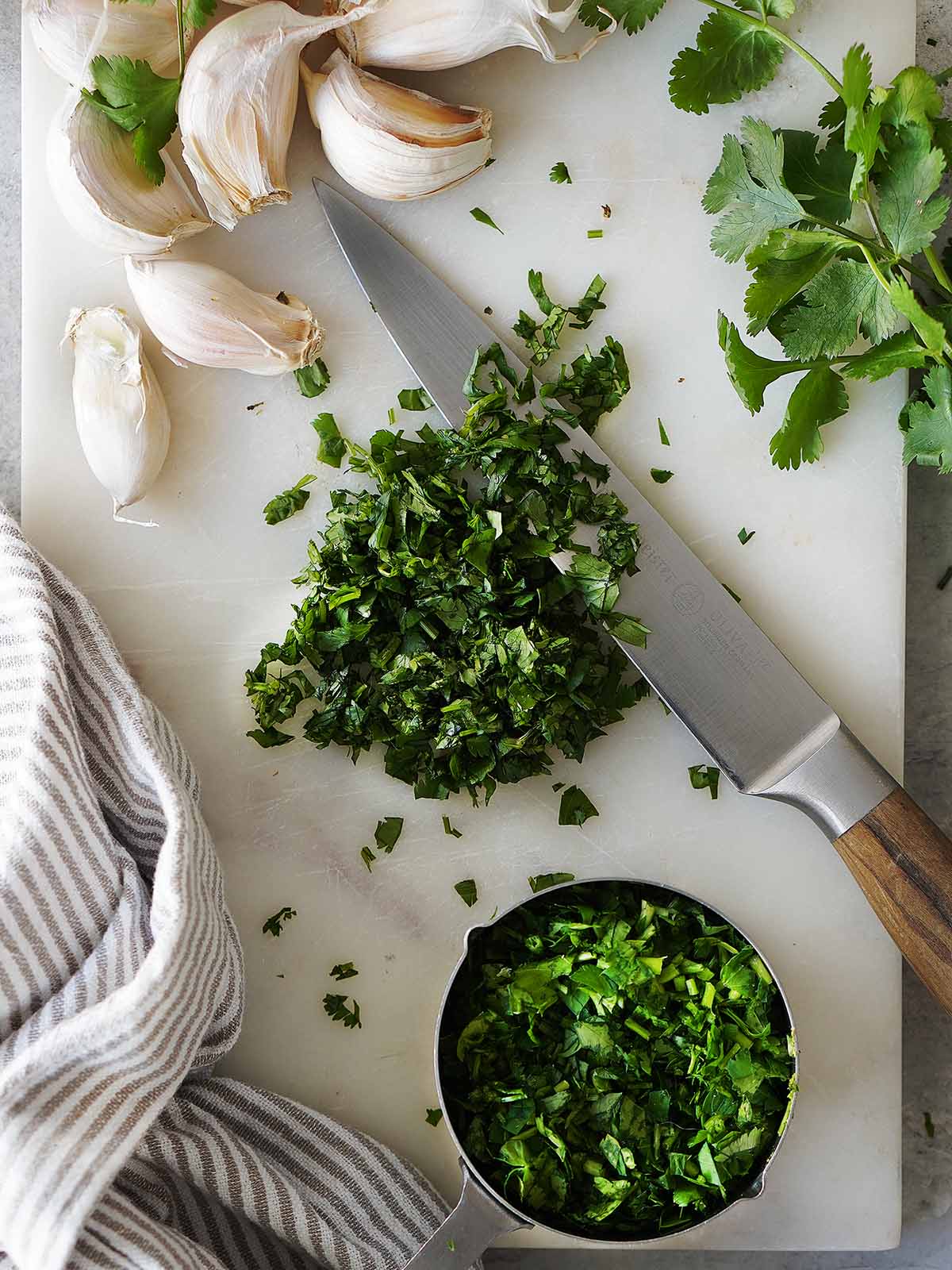 Fresh cilantro chopped on a white cutting board.