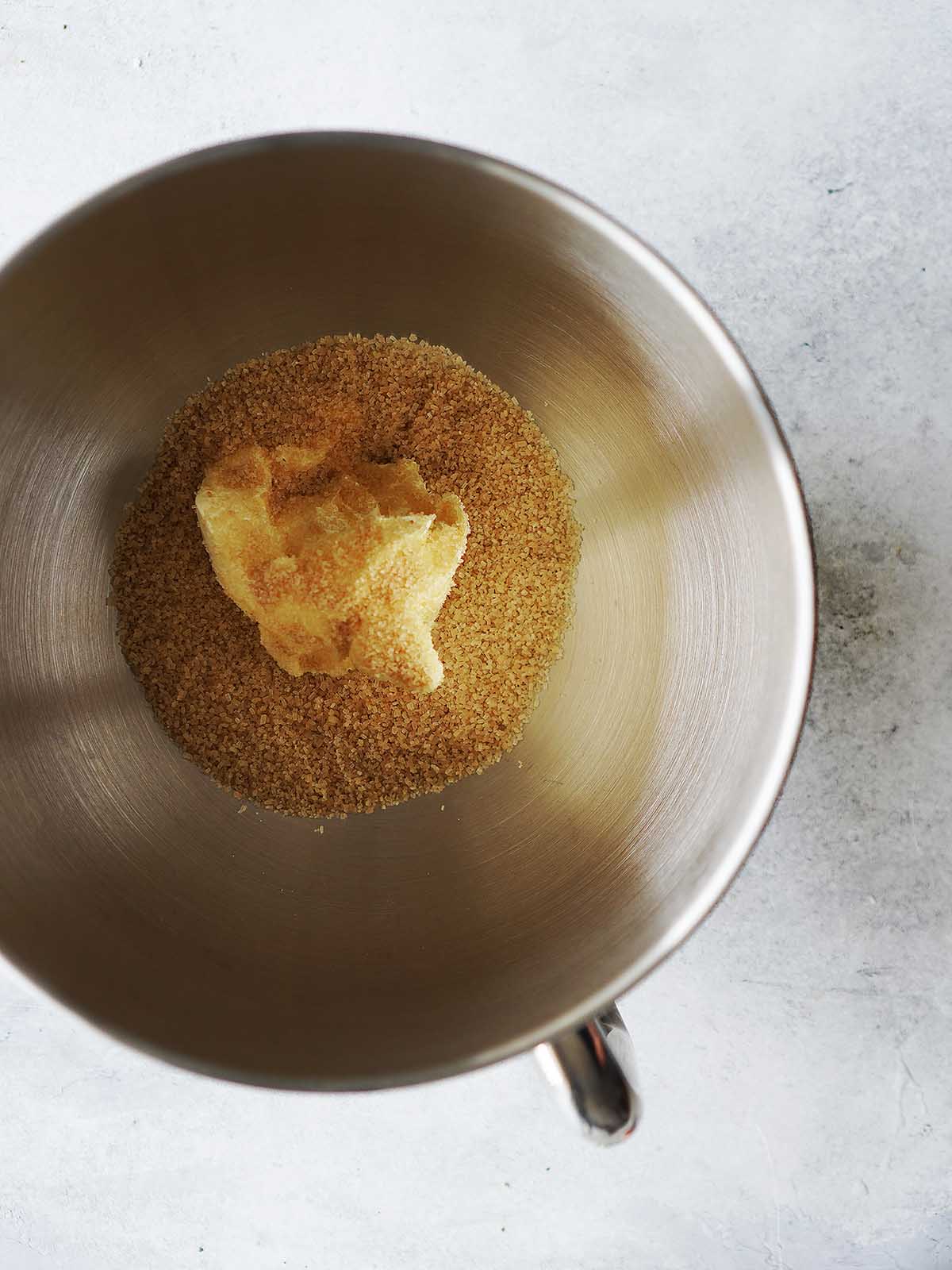 The bowl of a stand mixer with butter and sugar.