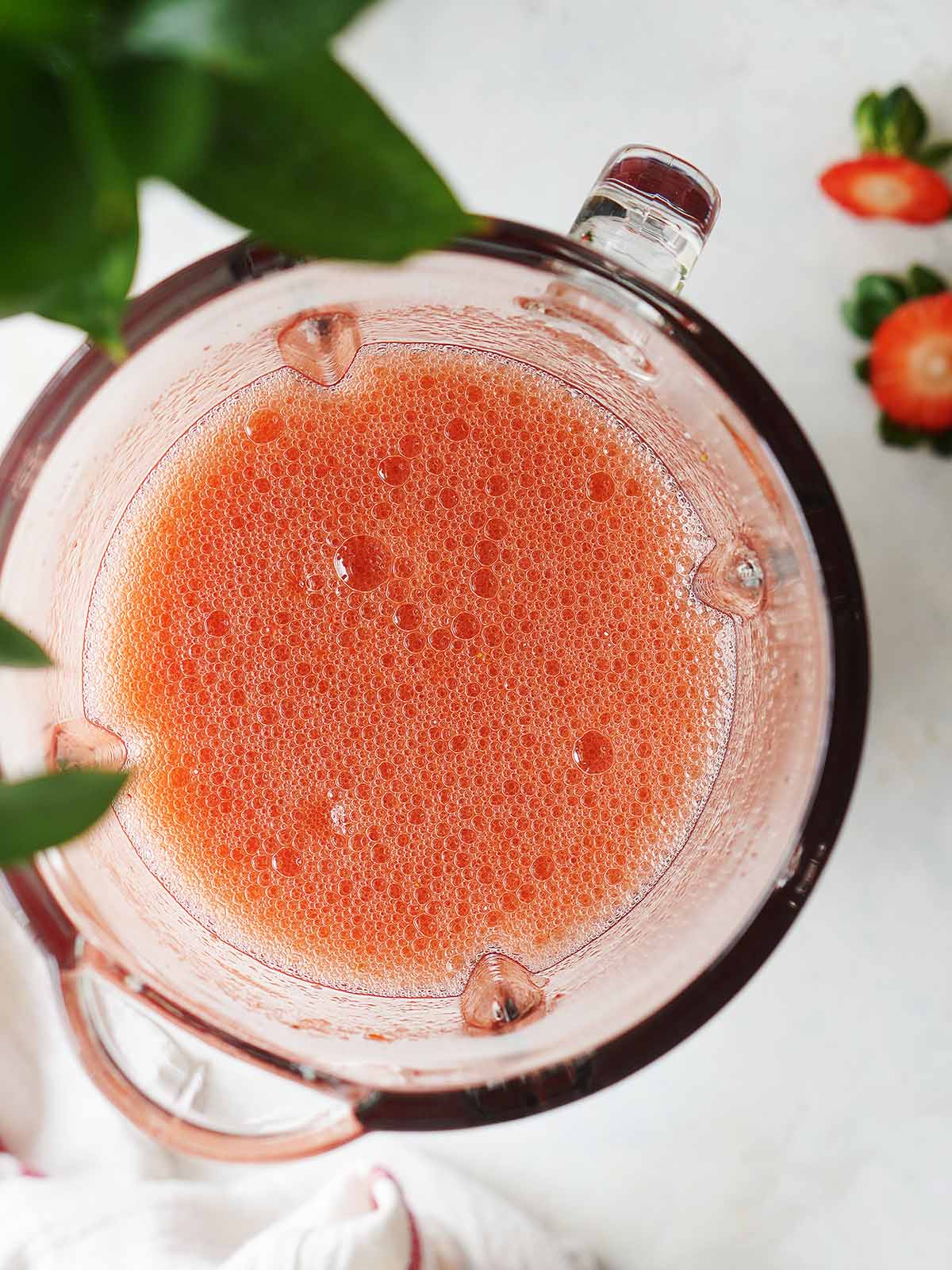 Blended strawberry juice in a blender's cup.