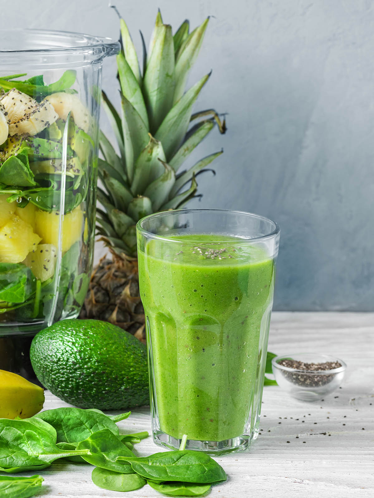 Ingredients for cooking healthy detox green smoothie in blender with glass of smoothie. Vegan cooking concept
