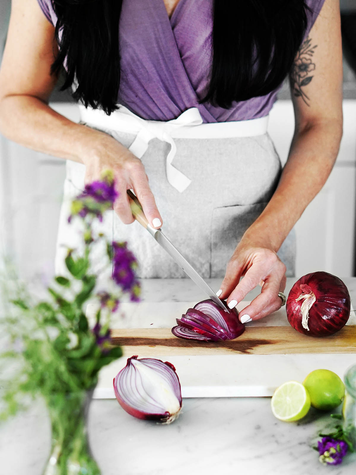 A woman slicing onions to make Mexican Red Onions.