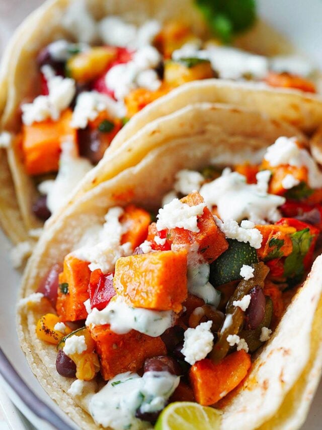 A close up of two veggie tacos in corn tortillas.