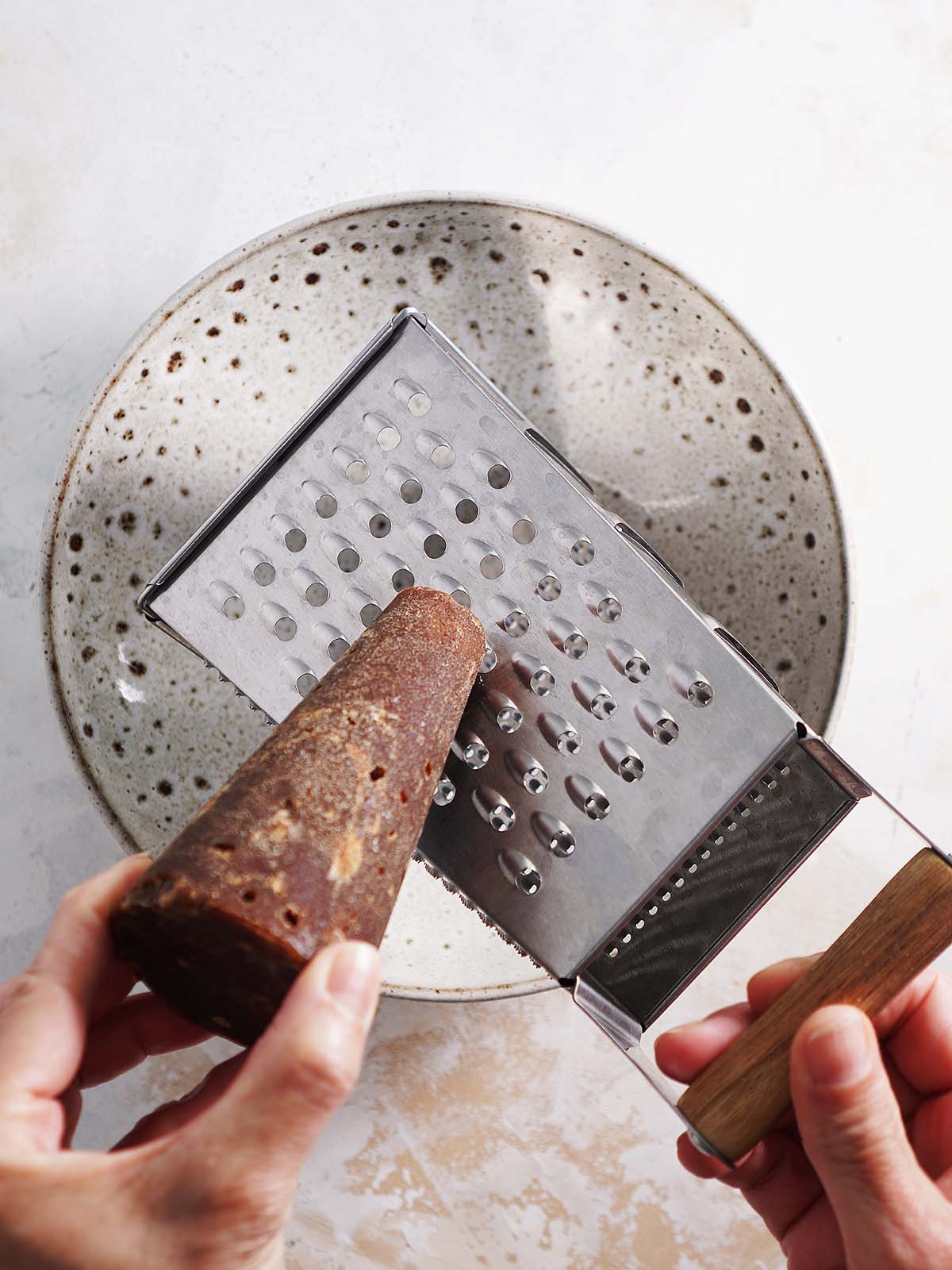 Grating piloncillo on a cheese grater.