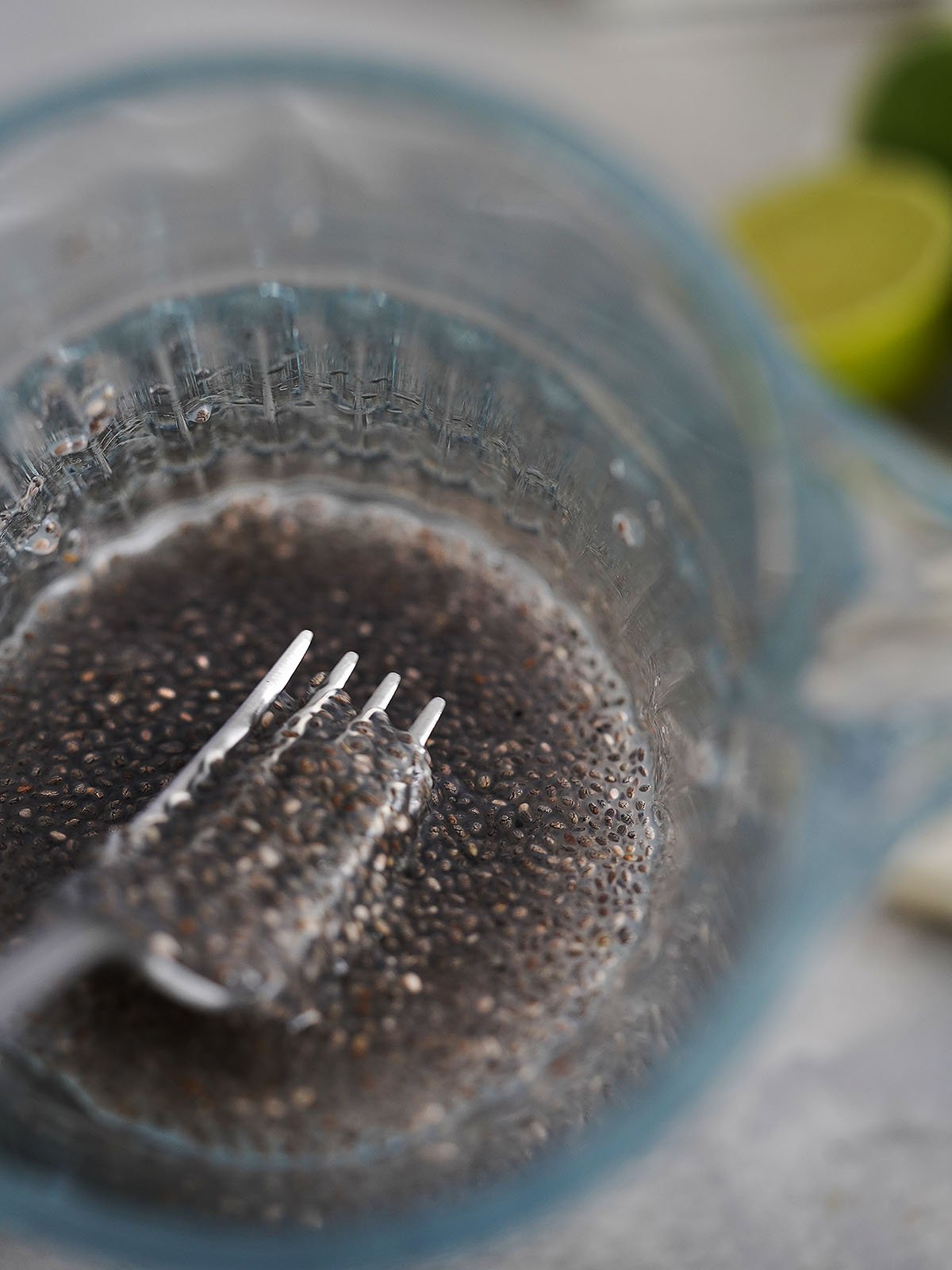 A jar filled with hydrated chia seeds a fork holding some of it.