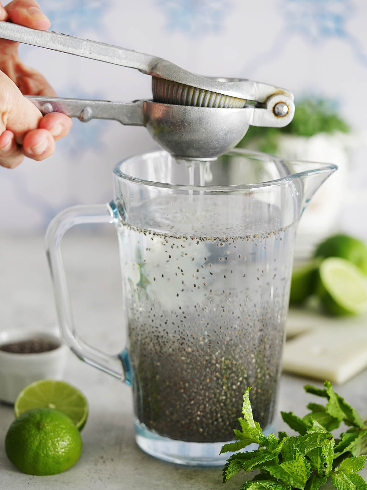 Squeezing lime into a jar with water and chia seeds.