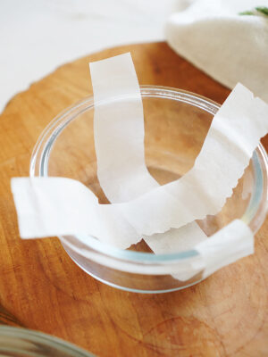 A small bowl lined with two strips of baking paper.
