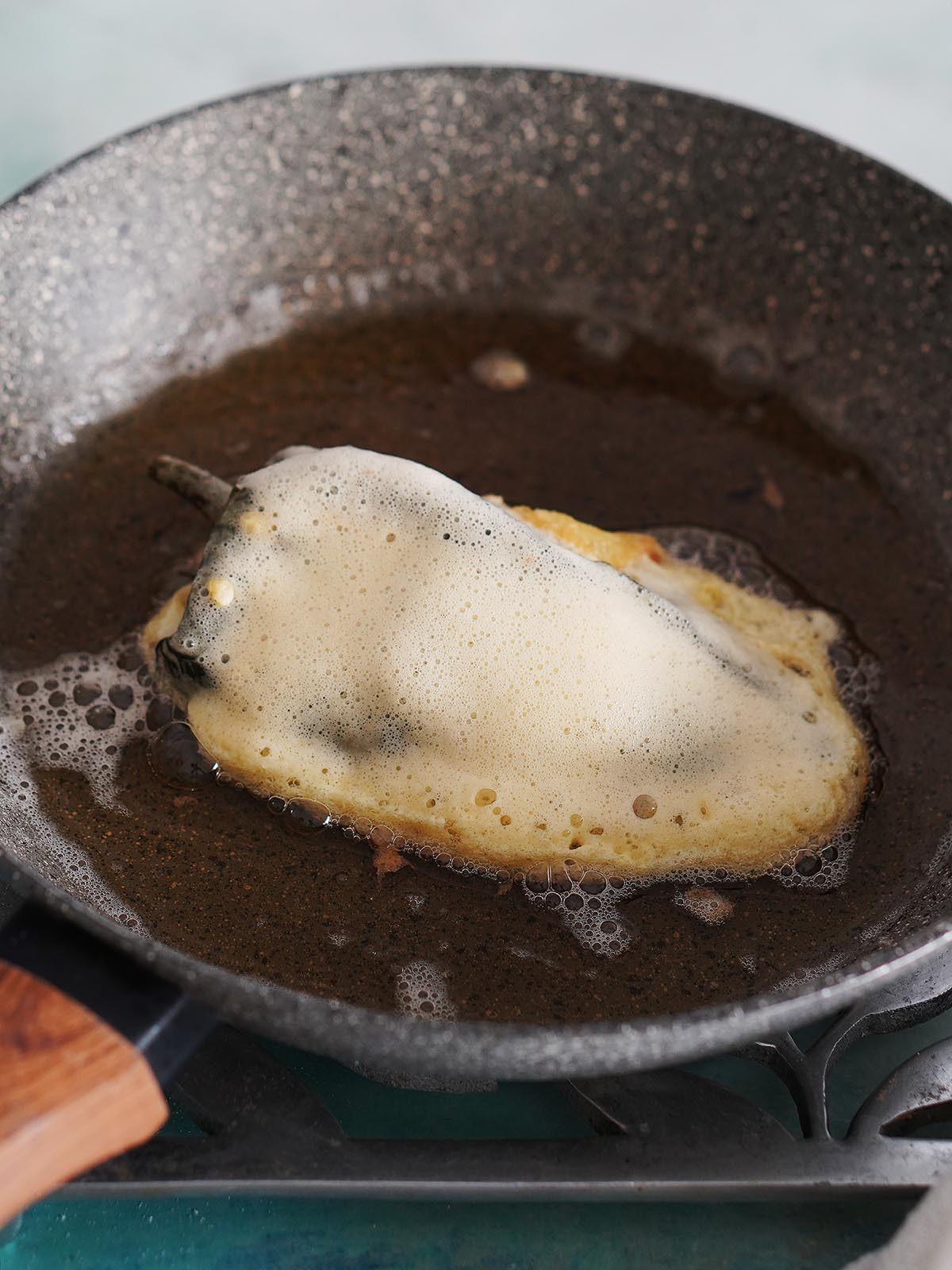 Frying in oil the chile relleno.