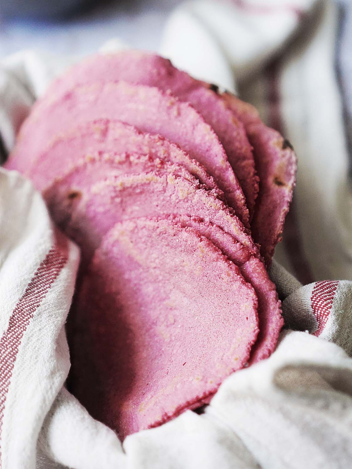 A stack of pink tortillas in a kitchen towel.