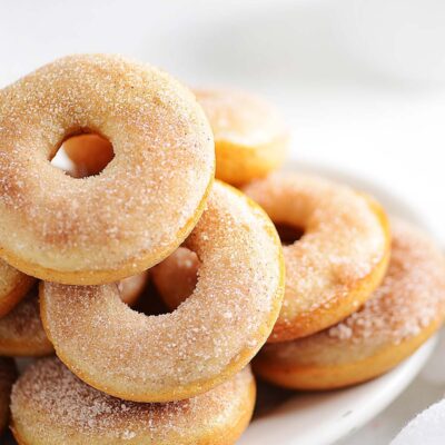 Cinnamon donuts placed on a plate as a stack.