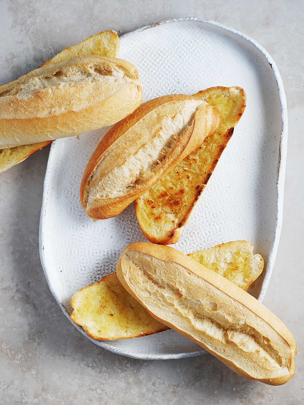 Bolillo bread sliced in half and toasted with butter.