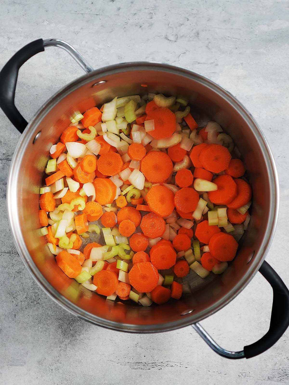 Sauteing onions, celery and carrots in a large stockpot.