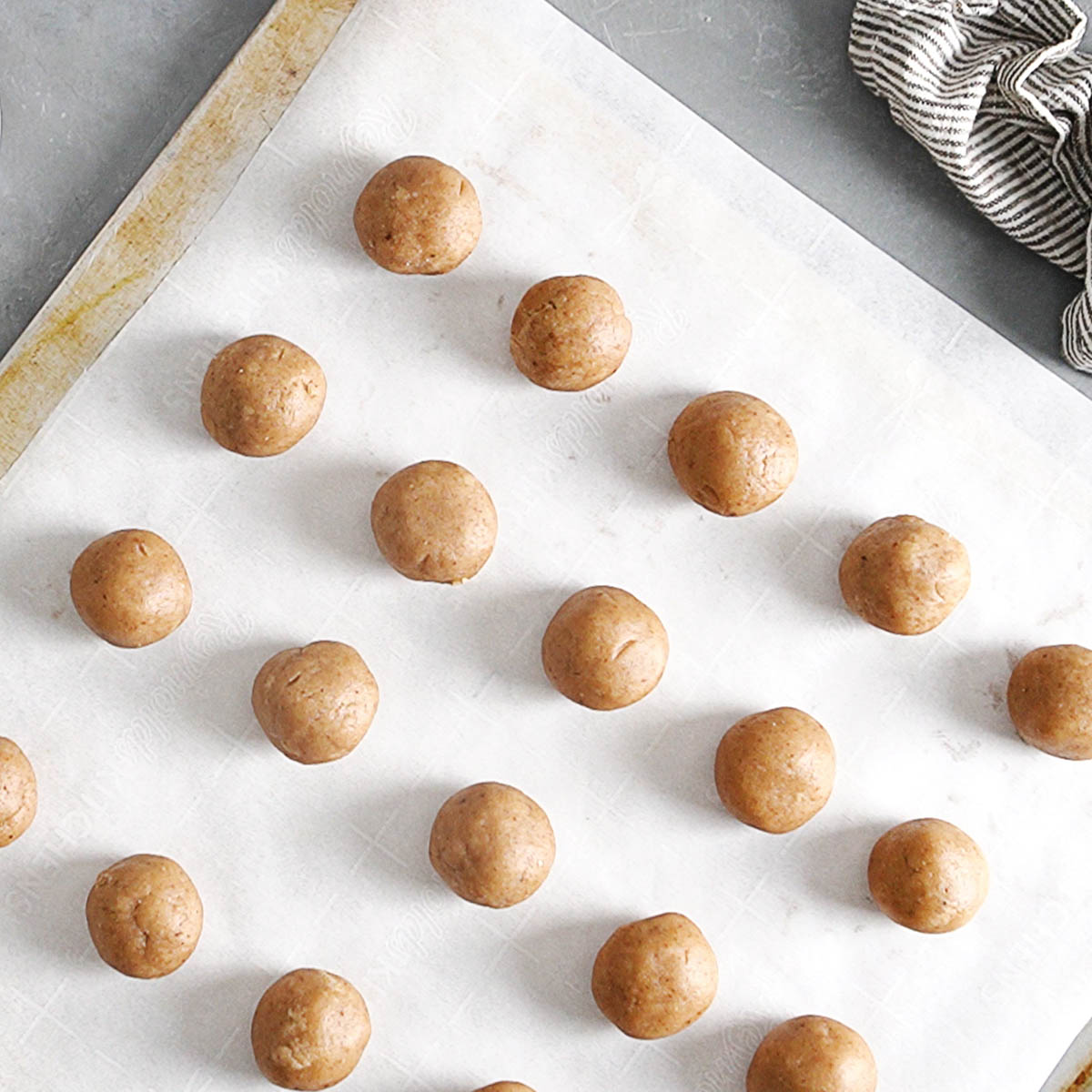 A baking tray with cookie dough balls.