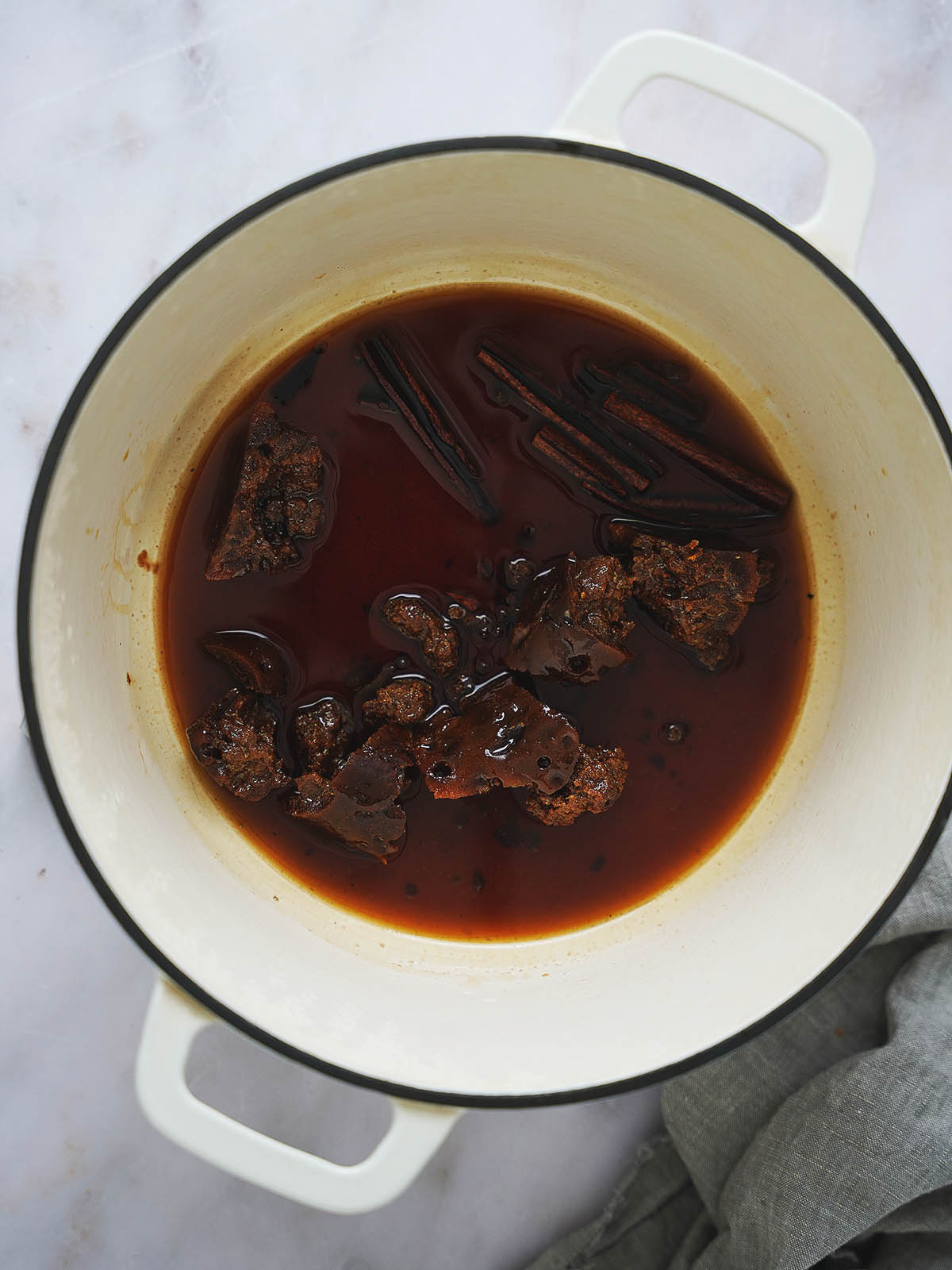 A pot with the piloncillo, cloves and cinnamon melted.