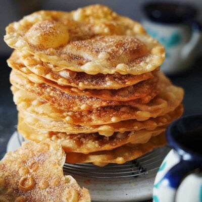 A stack of buñuelos on a white plate.