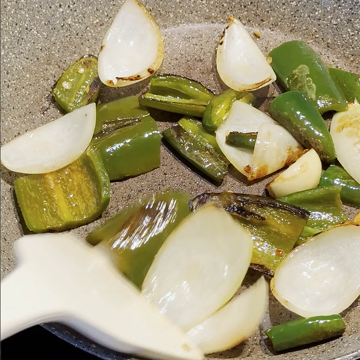 Sauteing onions and jalapeños in a skillet.