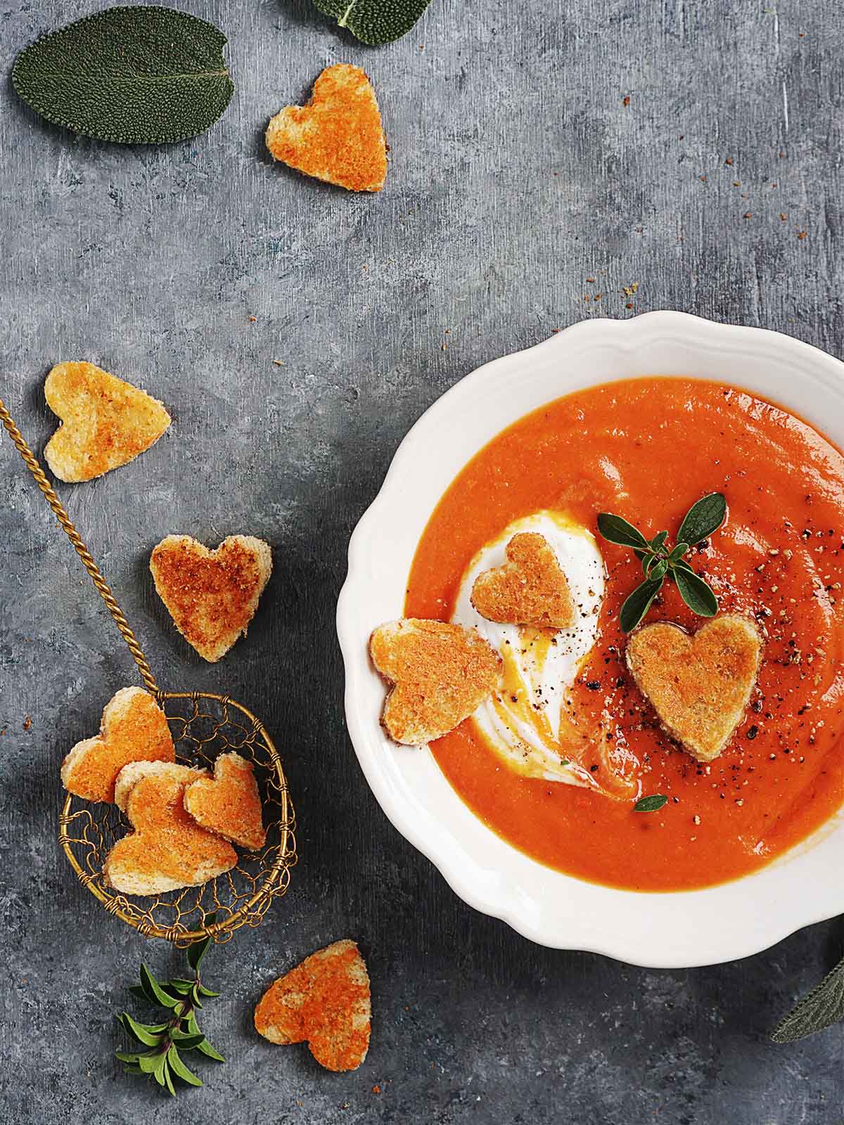 A bowl of crema de calabaza with croutons in the shape of hearts.