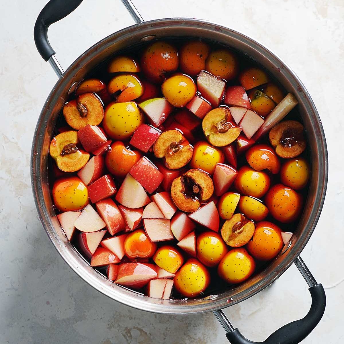 A large pot filled with fruit and punch.