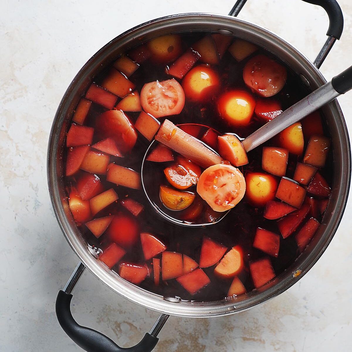 A large pot with punch and fruit.