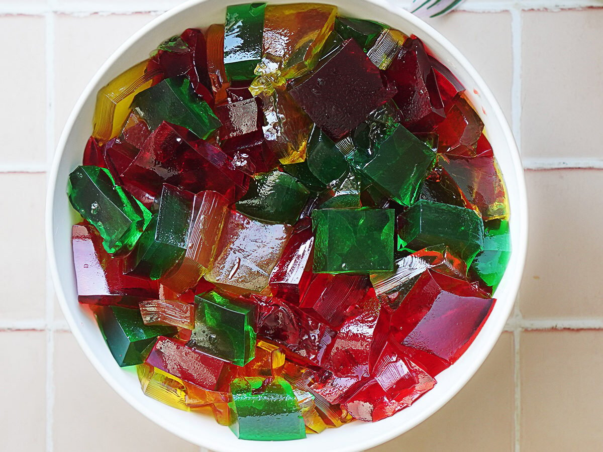 A bowl with mixed color jellos cut into squares