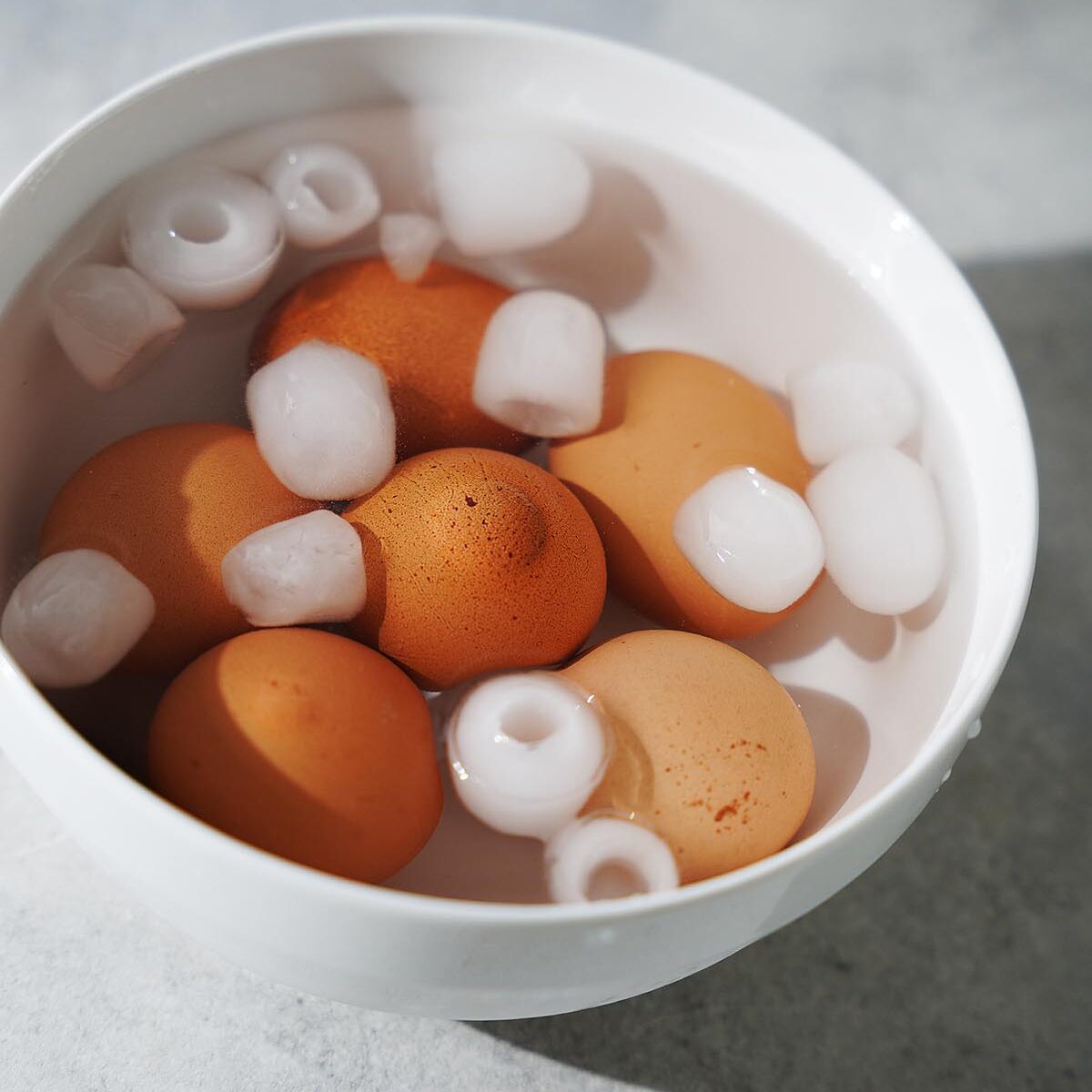 The cooked eggs placed inside a bowl with water and ice.