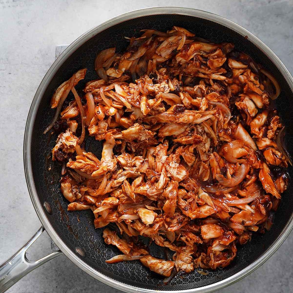 The shredded chicken mixture on a skillet.