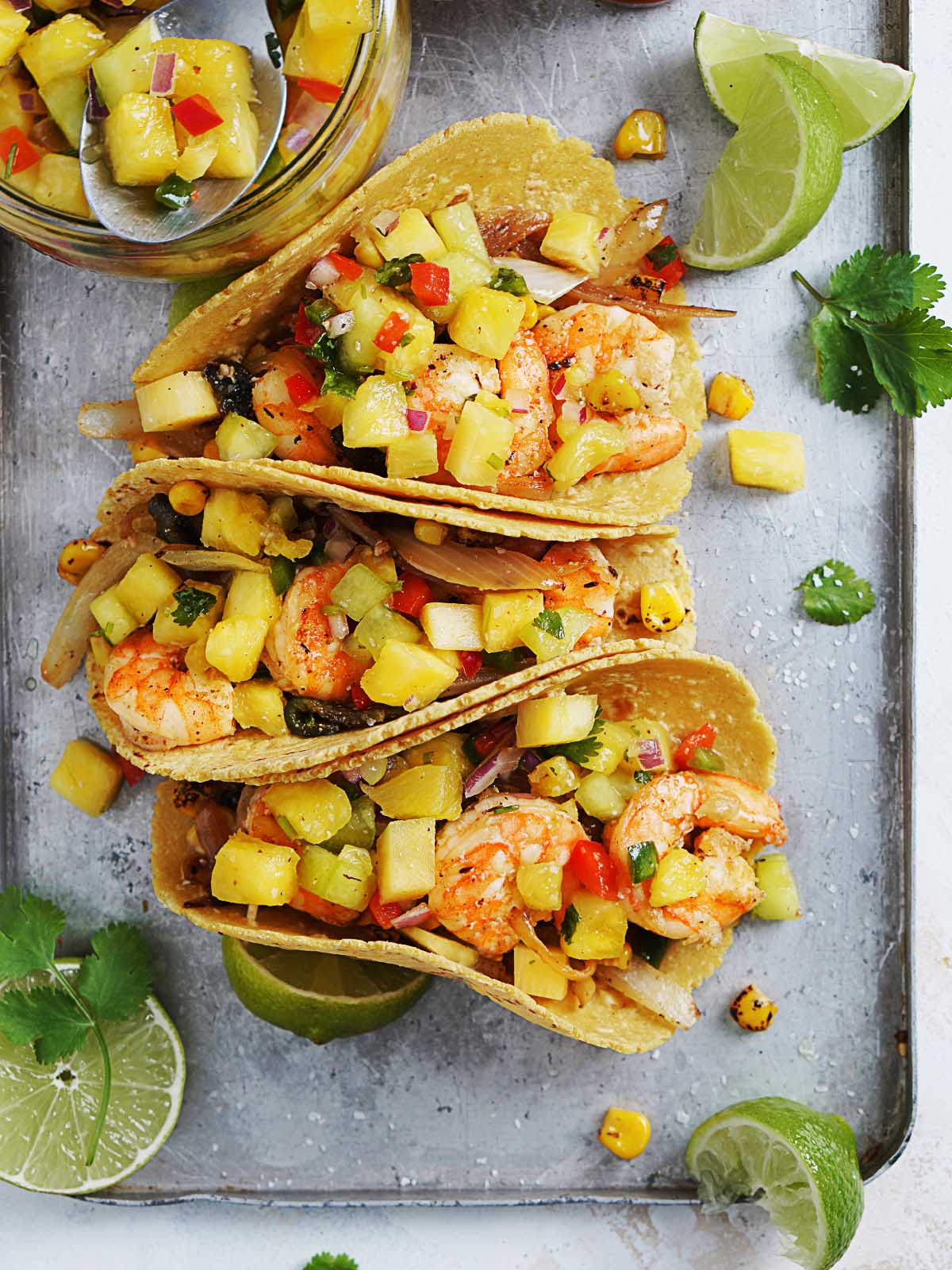 A tray with shrimp tacos topped with pineapple salsa. 