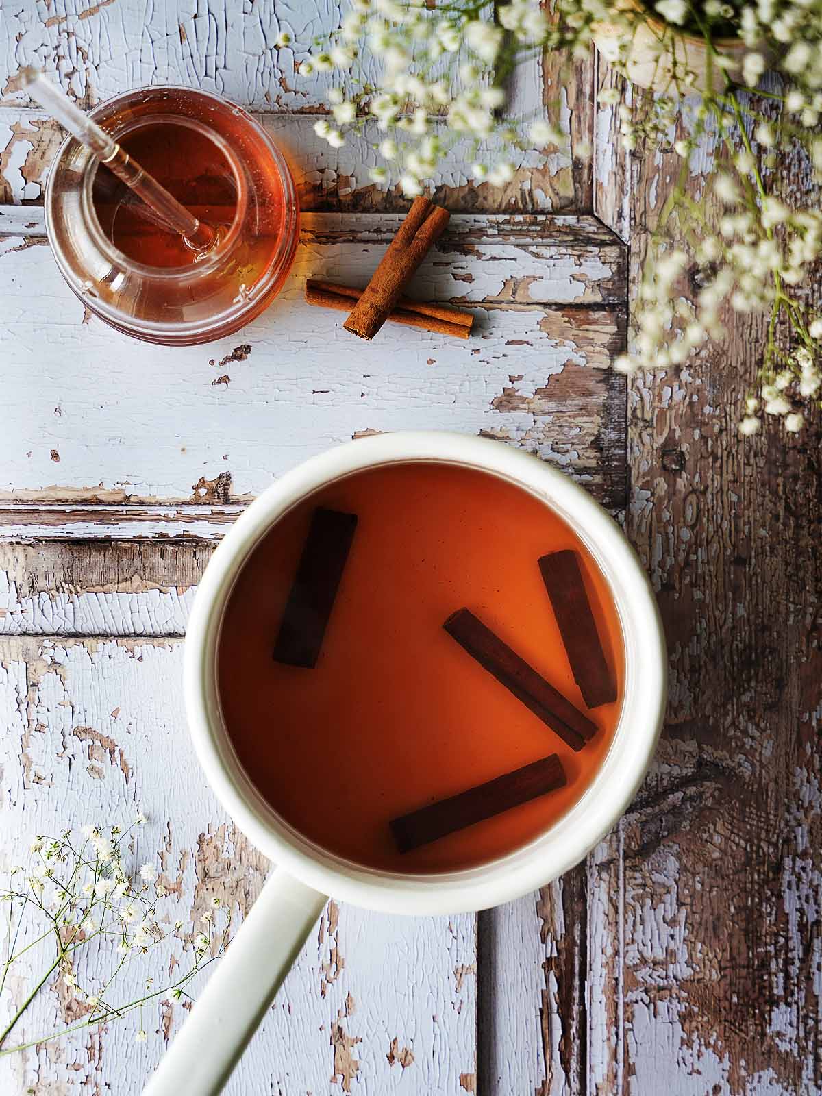 Cinnamon tea brewing in a saucepot.