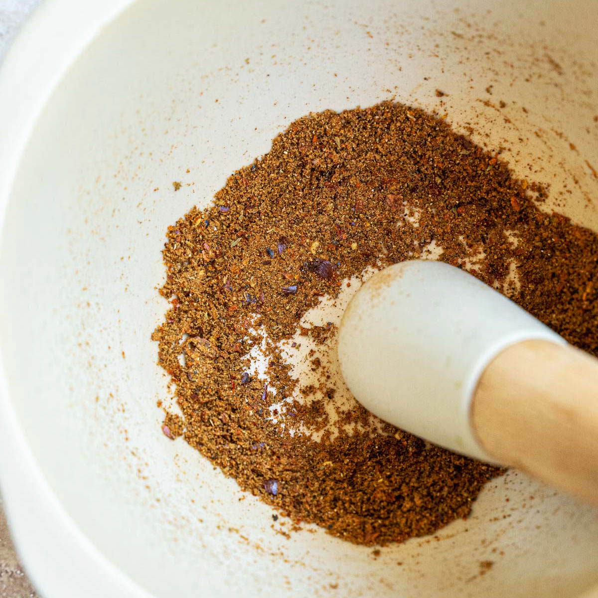 The spices grounded in a pestle and mortar.