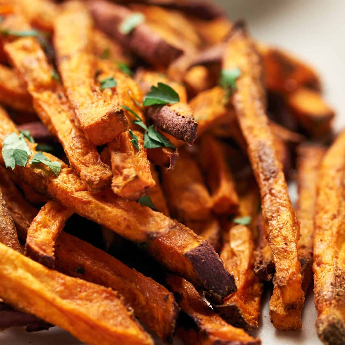 A white plate with a pile of sweet potato fries.
