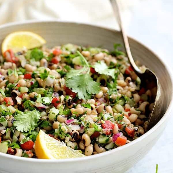 A white bowl with black eyed pea salad.