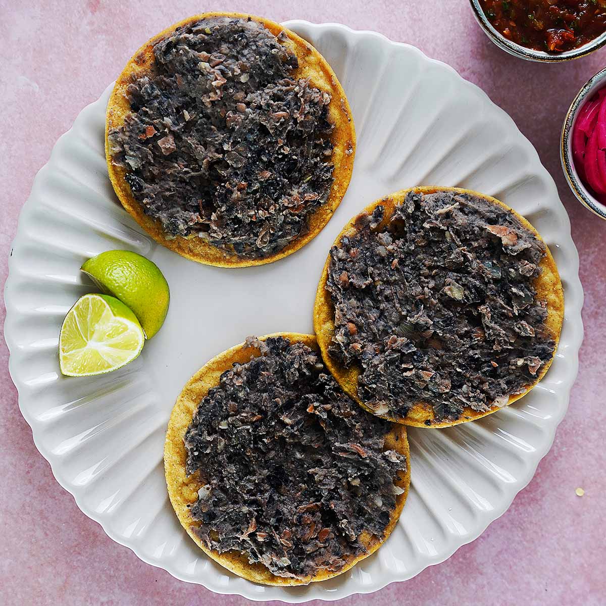 Three corn tostadas loaded with black beans.