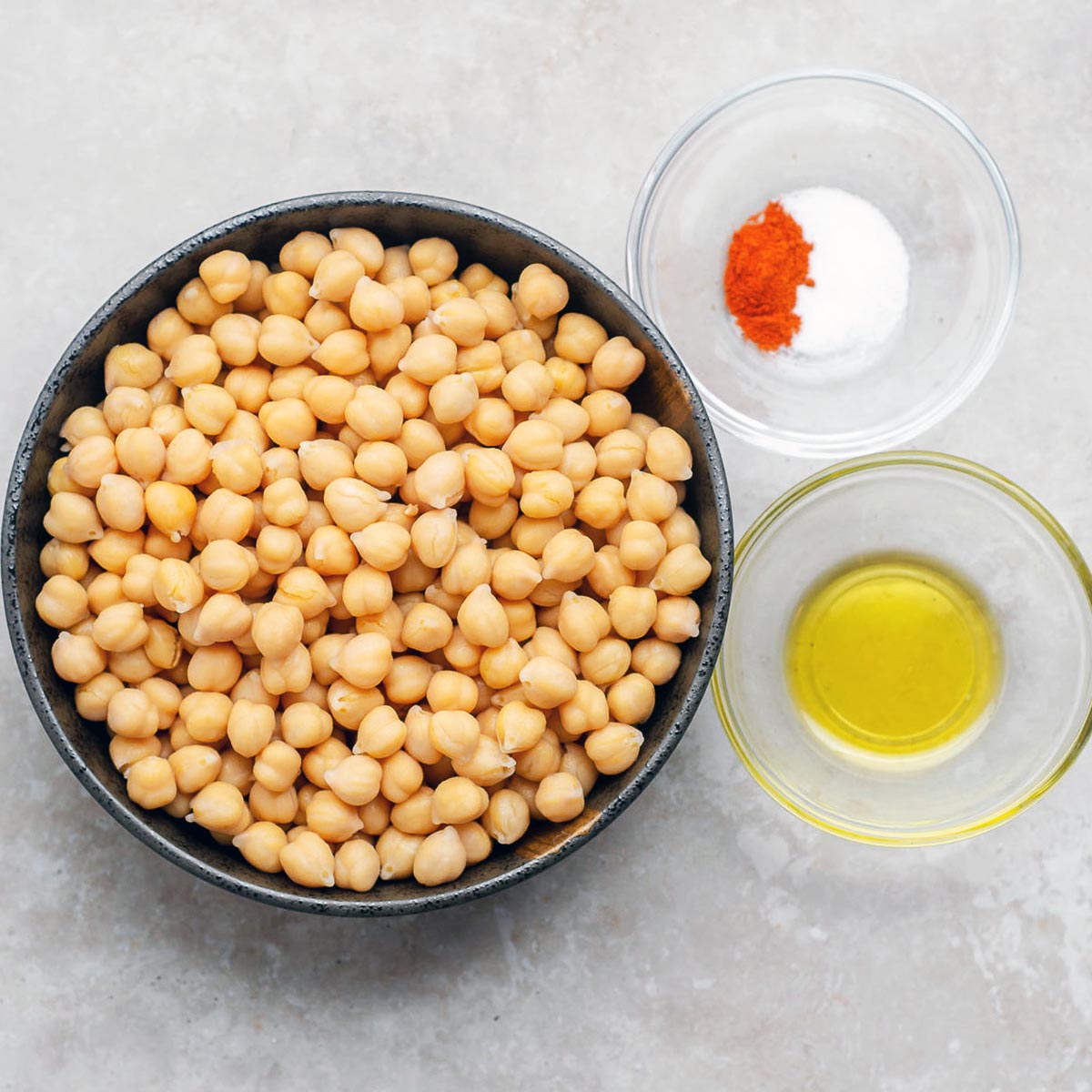A bowl with canned chickpeas, and the seasonings on the side.